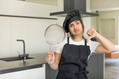 Genç bir kadın kendini kötü hissediyor, baş parmağını kaldırıyor. Şef konsepti