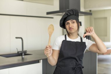 Genç bir kadın kendini kötü hissediyor, baş parmağını kaldırıyor. Şef konsepti