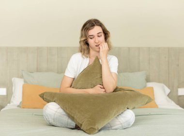 Güzel bir kadın korkmuş, endişeli ya da kızgın hisseder ve yana bakar. Gece elbisesi ve yatak odası konsepti