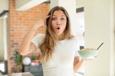 Güzel kadın mutlu, şaşkın ve şaşırmış görünüyor. Kahvaltı kasesi konsepti