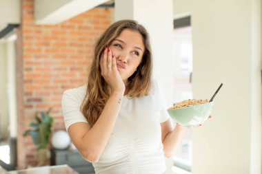 Güzel bir kadın bıkkın, hayal kırıklığına uğramış ve yorucu bir geceden sonra uykulu hissediyor. Kahvaltı kasesi konsepti