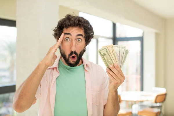 crazy bearded man looking happy, astonished and surprised. dollar banknotes concept