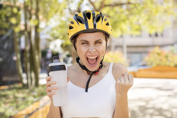 Genç ve güzel bir kadın sinirli, sinirli ve sinirli görünüyor. bisiklet kaskı konsepti