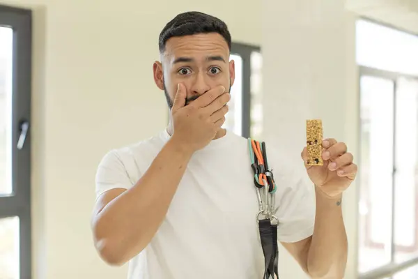 arab handsome man arab man covering mouth with a hand and shocked or surprised expression.  fitness and cereal bar concept