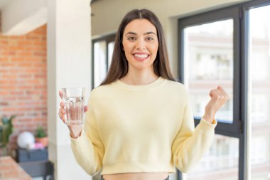 Oldukça genç bir model şok olmuş hissediyor, gülüyor ve başarıyı kutluyor. su camı konsepti