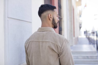 Profil görünümündeki genç yakışıklı adam ilerideki boşluğu kopyalamaya çalışıyor, düşünüyor, hayal ediyor ya da hayal kuruyor.