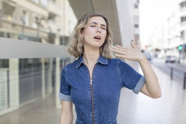 Güzel bir kadın stresli, endişeli, yorgun ve hayal kırıklığına uğramış, gömleğini çekmiş, sıkıntılı görünüyor.