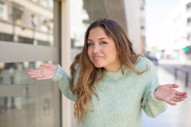 pretty hispanic woman feeling clueless and confused, having no idea, absolutely puzzled with a dumb or foolish look