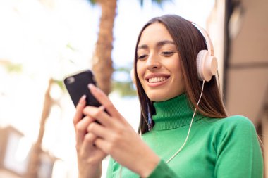 Akıllı telefon kullanan bir model.