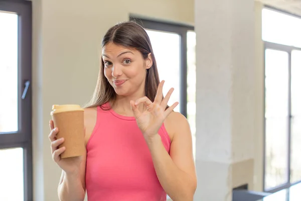 若い女性は喜んでいます良いジェスチャーで承認を示します コーヒーの概念を取り上げ — ストック写真