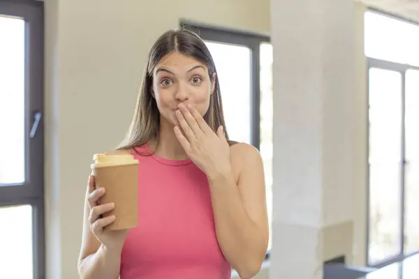 若い可愛い女が手で口を覆いショックや驚きの表情で コーヒーの概念を取り上げ — ストック写真