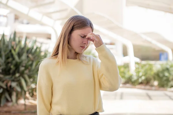 かなり若い女性はストレスを感じ 不満を感じ 額に触れ 重度の頭痛の片頭痛に苦しんでいます — ストック写真