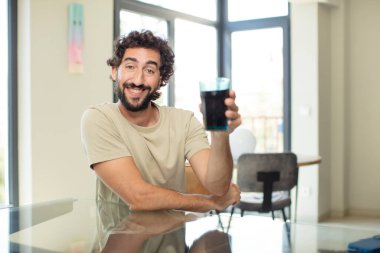 Elinde kola bardağı olan genç bir adam.