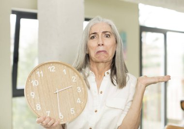 Saati olan yaşlı bir kadın.