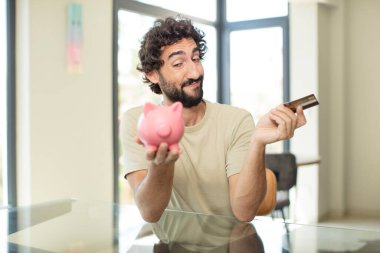 Sakallı İspanyol adam kredi kartıyla alışveriş yapıyor.