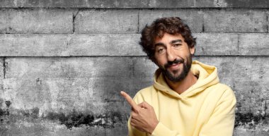 Neşeli bir şekilde gülümseyen, mutlu hisseden, kenarı ve yukarıyı gösteren, kopya uzayda nesneleri gösteren