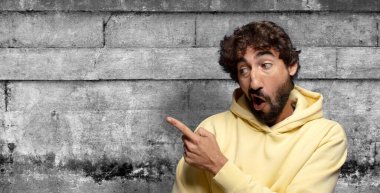 Neşeli ve şaşırmış hissediyorum, şok olmuş bir ifadeyle gülümsüyorum ve bir tarafı işaret ediyorum.