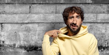 Stresli, endişeli, yorgun ve hayal kırıklığına uğramış, gömleğini çekmiş, sorunlu görünüyor.