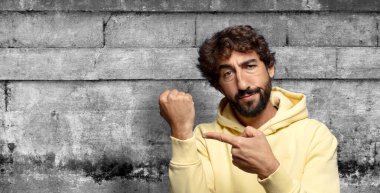 Sabırsız ve kızgın görünüyor, saatine bakıyor, dakiklik istiyor, zamanında gelmek istiyor.