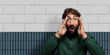 Heyecanlı ve şaşırmış görünüyor, ağzı açık, elleri başının üstünde, şanslı bir kazanan gibi hissediyor.