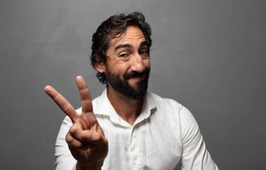 Gülümseyen ve mutlu görünen, kaygısız ve pozitif, tek elle zafer ya da barış işareti yapan