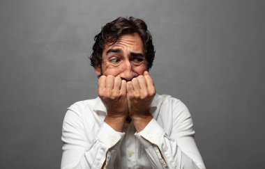 Endişeli, endişeli, stresli ve korkmuş görünüyor, tırnaklarını yiyor ve yanal kopya alanı arıyor.