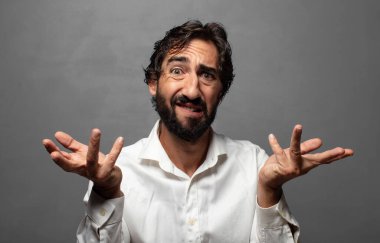 Şaşırmış, kafası karışmış ve stresli görünüyor, farklı seçenekler arasında merak ediyor, kararsız hissediyor.