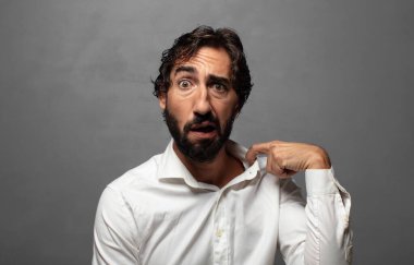 Stresli, endişeli, yorgun ve hayal kırıklığına uğramış, gömleğini çekmiş, sorunlu görünüyor.