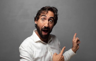 Neşeli ve şaşırmış hissediyorum, şok olmuş bir ifadeyle gülümsüyorum ve bir tarafı işaret ediyorum.