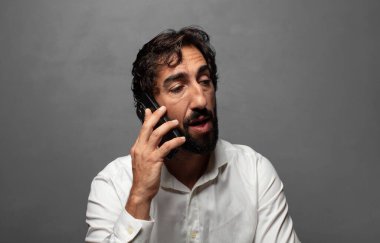 Genç yetişkin bir adam akıllı telefon kullanıyor.