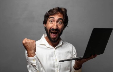 Genç bir adam dizüstü bilgisayar kullanıyor.