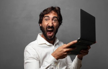 Genç bir adam dizüstü bilgisayar kullanıyor.