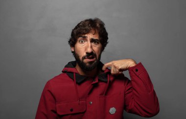 Stresli, endişeli, yorgun ve hayal kırıklığına uğramış, gömleğini çekmiş, sorunlu görünüyor.