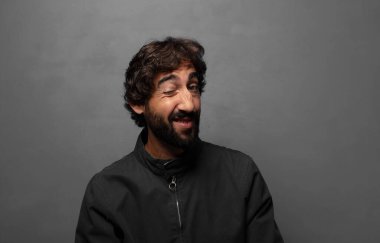 Mutlu ve arkadaş canlısı görünüyor, gülümsüyor ve sana olumlu bir tavırla göz kırpıyor.