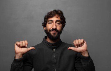 Gururlu, kibirli ve kendinden emin, tatmin olmuş ve başarılı görünüyor, kendini işaret ediyor.