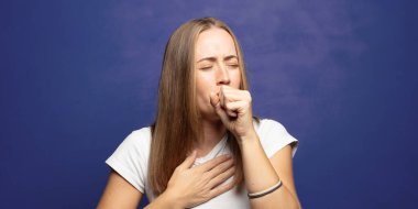 Boğaz ağrısı ve grip belirtileri var. Ağzı kapalı öksürüyor.