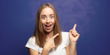 Neşeli ve şaşırmış hissediyorum, şok olmuş bir ifadeyle gülümsüyorum ve bir tarafı işaret ediyorum.