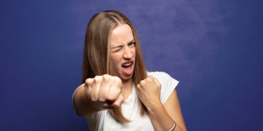 Kendinden emin, sinirli, güçlü ve agresif görünüyor. Yumrukları boks pozisyonunda dövüşmeye hazır.