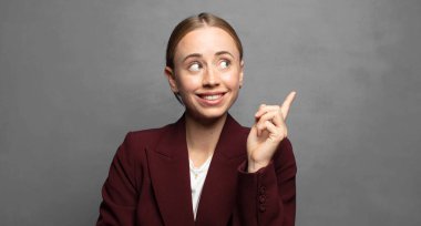 Mutlu bir şekilde gülümsemek ve yan bakmak, merak etmek, düşünmek ya da bir fikir sahibi olmak.