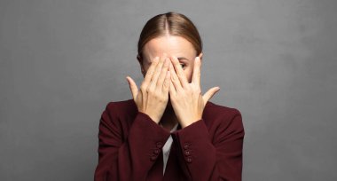 Yüzü ellerle kaplamak, parmaklarının arasından bakmak şaşırmış bir ifadeyle yan tarafa bakmak.