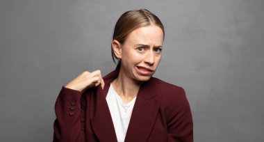 Stresli, endişeli, yorgun ve hayal kırıklığına uğramış, gömleğini çekmiş, sorunlu görünüyor.