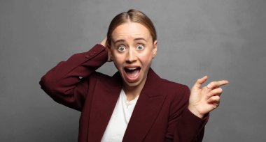 Gülüyor, mutlu, pozitif ve şaşırmış görünüyor. Yan fotokopi alanını işaret eden harika bir fikri fark ediyor.