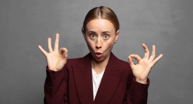 Şaşırmış, şaşırmış ve şaşırmış hissediyorsun. Onayladığını gösteriyorsun. İki elinle de onay imzası atıyorsun.