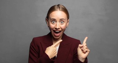 Neşeli ve şaşırmış hissediyorum, şok olmuş bir ifadeyle gülümsüyorum ve bir tarafı işaret ediyorum.