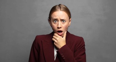 Ağzı ve gözleri açık ve elleri çenesinde, nahoş bir şekilde şokta, ne diyor ya da vay be