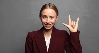 Mutlu, eğlenceli, kendinden emin, pozitif ve isyankar hissediyorum, elle kaya ya da heavy metal işareti yapıyorum.