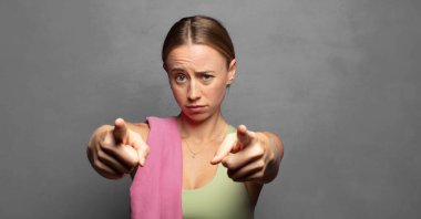 Kamerayı iki parmağınla ve kızgın bir ifadeyle sana görevini yapmanı söylüyor.