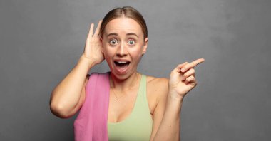 Gülüyor, mutlu, pozitif ve şaşırmış görünüyor. Yan fotokopi alanını işaret eden harika bir fikri fark ediyor.