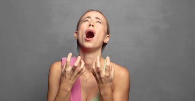 Çaresiz ve hayal kırıklığına uğramış görünüyor, stresli, mutsuz ve sinirli, bağırıyor ve çığlık atıyor