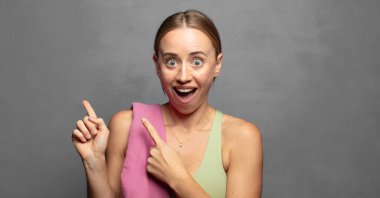 Neşeli ve şaşırmış hissediyorum, şok olmuş bir ifadeyle gülümsüyorum ve bir tarafı işaret ediyorum.